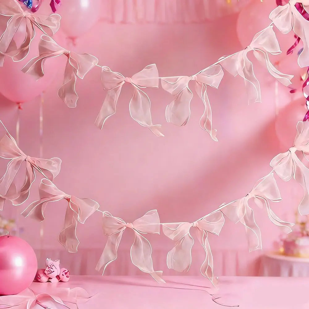 Pink sheer ribbon bow knot banner garland decorating a pink background for events