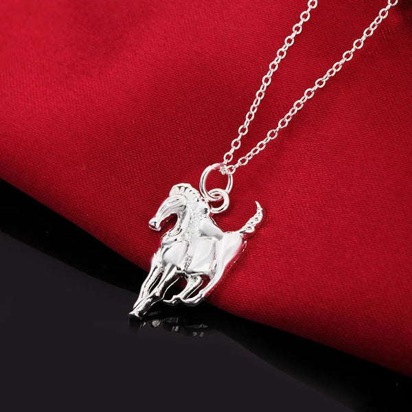 Collier pendentif en argent sterling de cheval sur fond de tissu rouge.