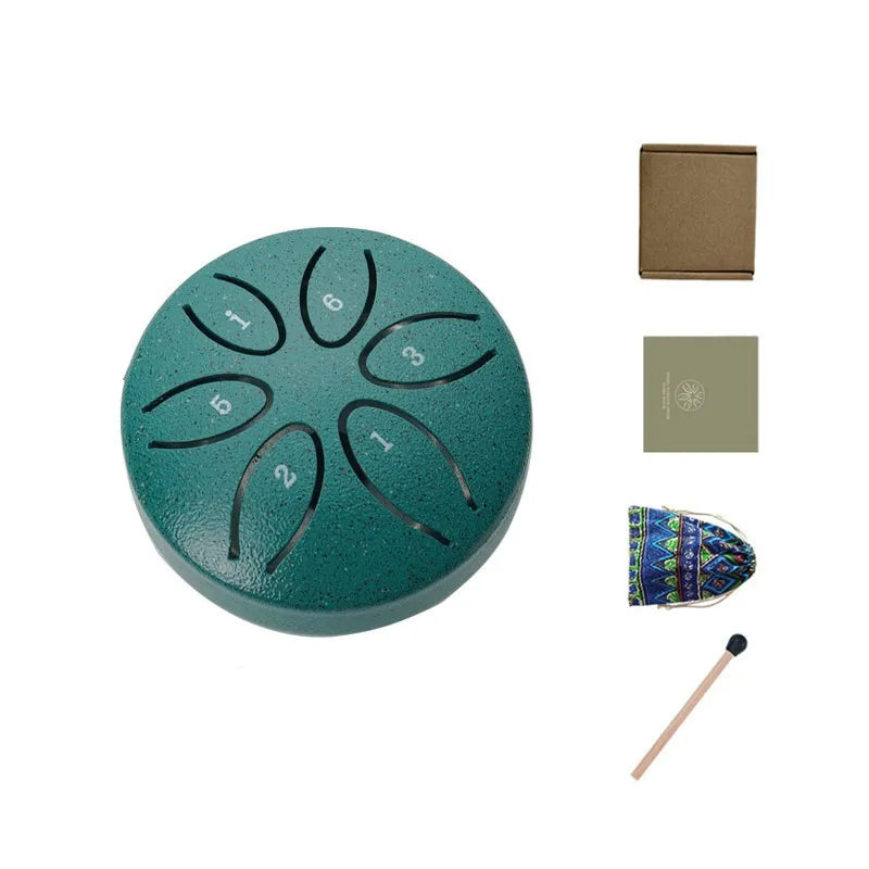 A teal steel tongue drum with six numbered holes and accompanying accessories for meditation.