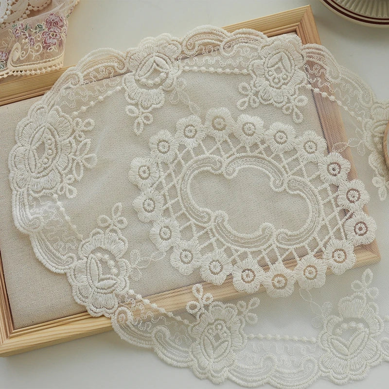 Elegant oval lace embroidered placemat with delicate floral patterns on a light beige fabric