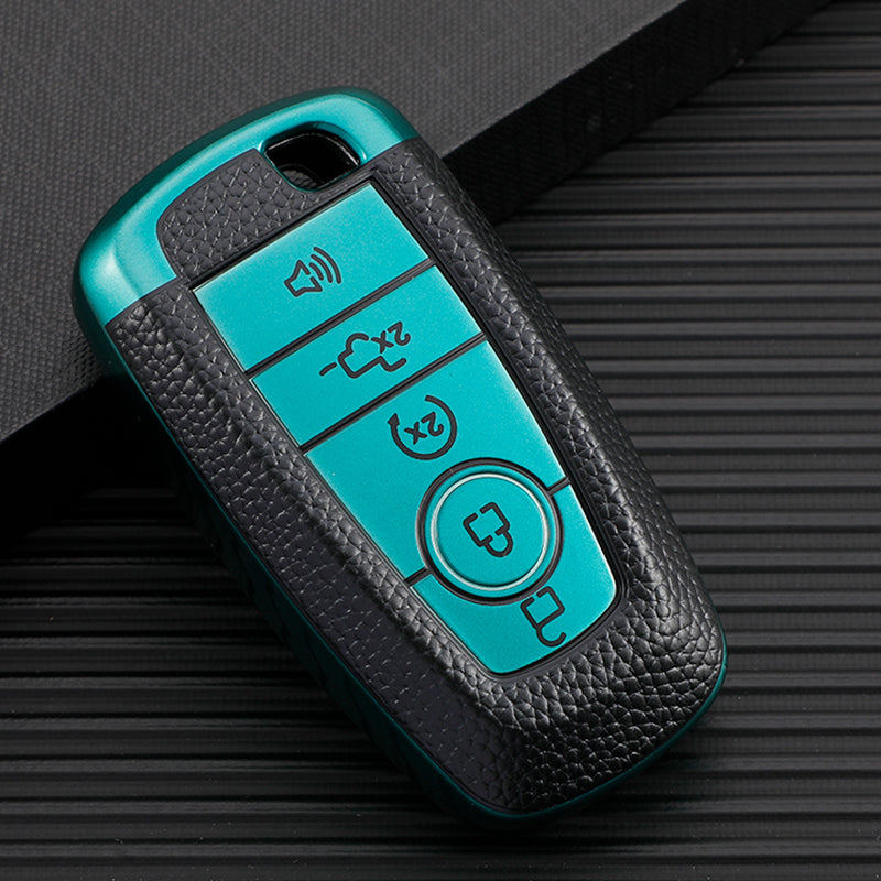 A teal TPU leather car key cover with multiple buttons is shown resting on a dark surface.
