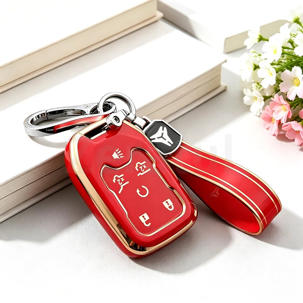 A red TPU smart key fob cover with a silver keychain attached, resting on a white surface next to a book.