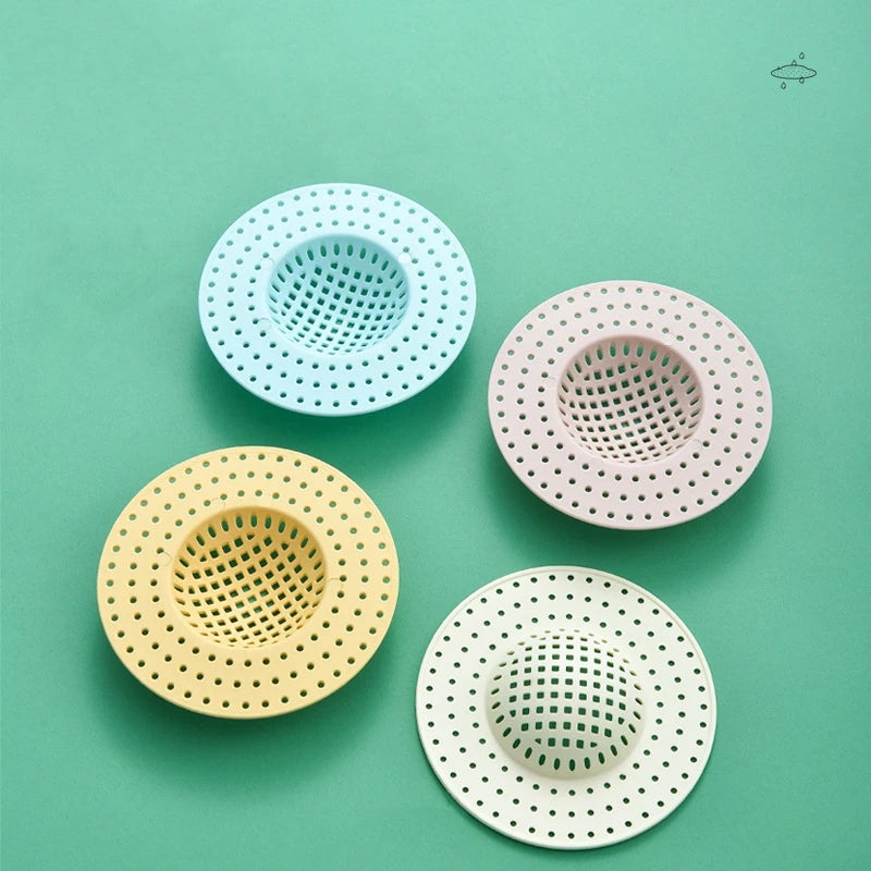 Four silicone sink drain filter strainers in various pastel colors, including light blue, pink, yellow, and white.