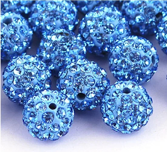A pile of small, round, blue crystal clay beads used for DIY jewelry and craft projects.