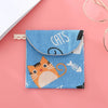 A blue fabric pouch for cosmetics featuring a cat design and a black clasp closure.