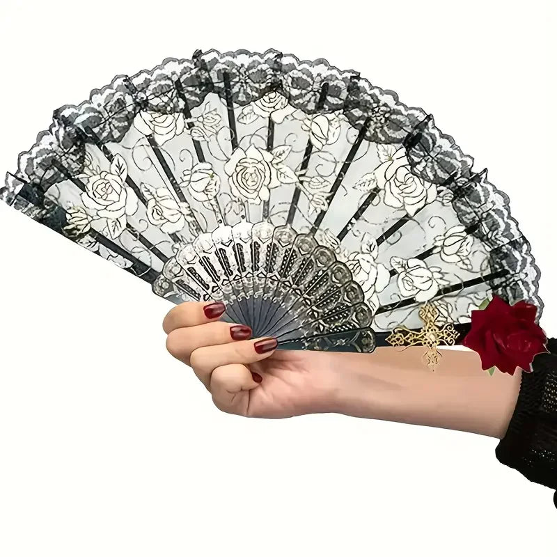 Eine Hand hält einen antiken spanischen Flamenco-Rosen-Spitzenfächer mit komplizierten Blumenmustern.