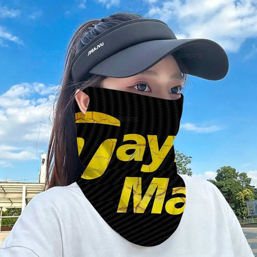 A person wearing a black and yellow striped neck gaiter covering their lower face outdoors.