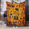 An orange Halloween themed flannel throw blanket featuring silhouettes of witches, bats, pumpkins, and spooky elements.