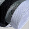 Close-up of a white reusable self-adhesive mosquito window screen material layered over black mesh fabric.