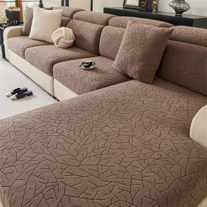 A cozy brown jacquard fleece sofa cover with anti-slip backing and decorative pillows.