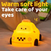 A yellow silicone touch control night light shaped like a taxi car resting on a white surface.
