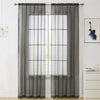 Two panels of sheer gray voile curtains hanging on a rod over a window.