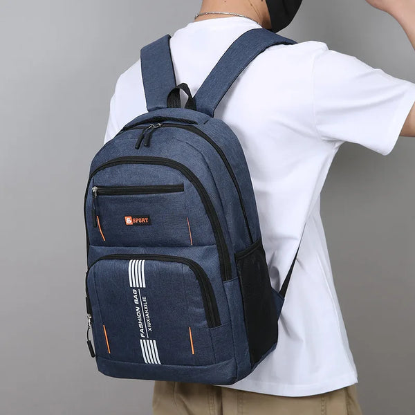 A dark blue commuter backpack worn by a person, featuring a laptop compartment and striped accents.