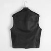 Black faux leather biker vest with a collar hanging on a hook.