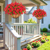 A hanging basket of bright red artificial morning glory flowers is displayed on a porch railing.