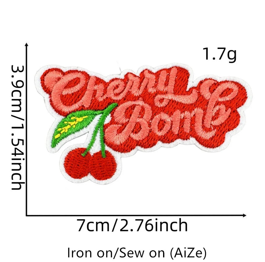 A red cherry embroidered patch featuring a green leaf on white fabric.