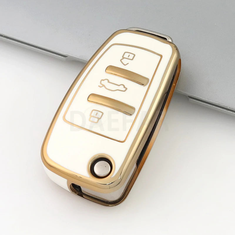 A close-up view of a white and gold protective TPU key fob cover for an Audi flip key.