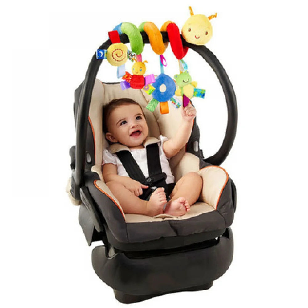 A soft plush hanging baby toy set with yellow and red elements is shown inside a black carrier.