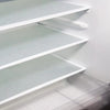 A close-up view of three white, textured shelf liners installed inside a refrigerator, showing the interior shelving.