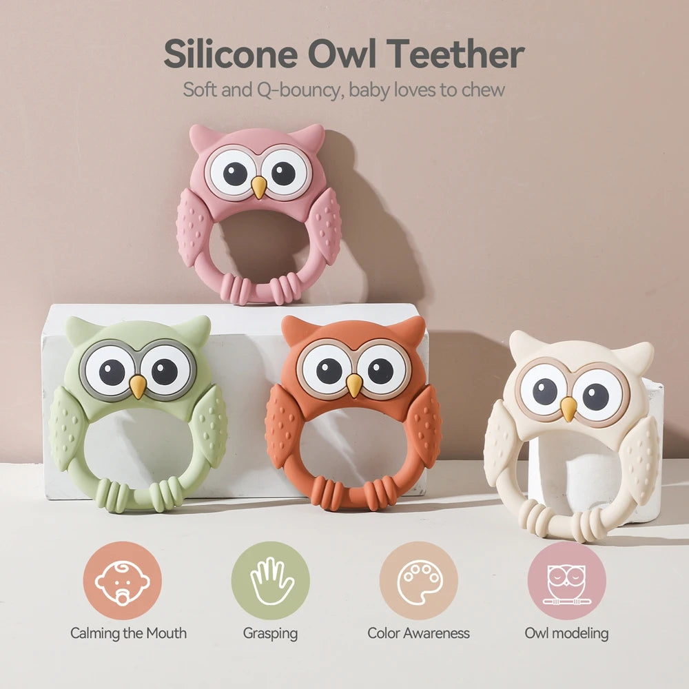A set of silicone owl teethers in pink, orange, and cream colors shown against a white background.
