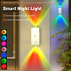 A smart night light emitting a rainbow gradient lighting effect on a wall, with a plant in the foreground.