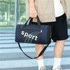 A person is holding a dark blue duffel bag with a white 'sport' logo, standing outdoors.