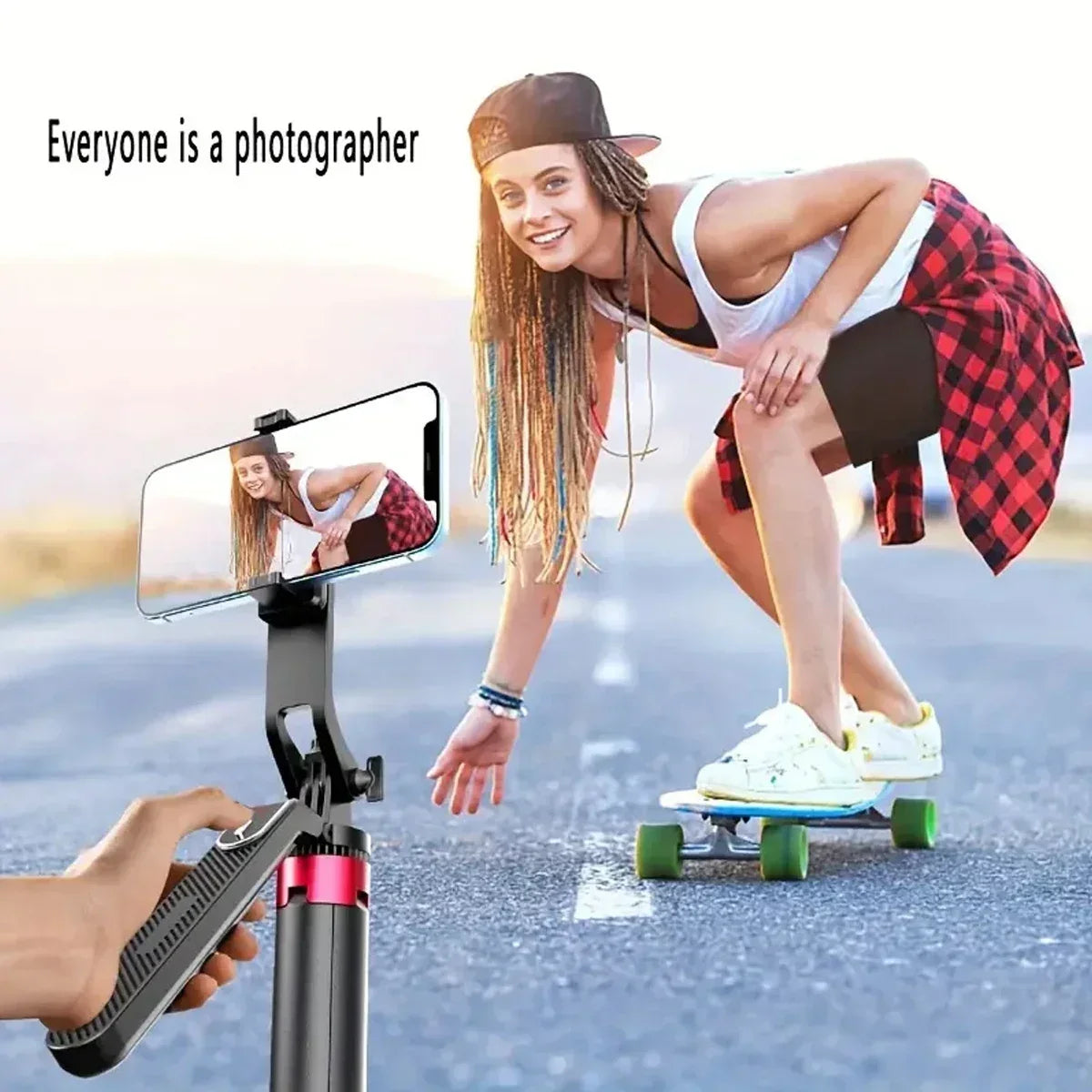 A young woman is using a portable aluminum camera tripod with a wireless remote to take a mirror selfie on a skateboard.