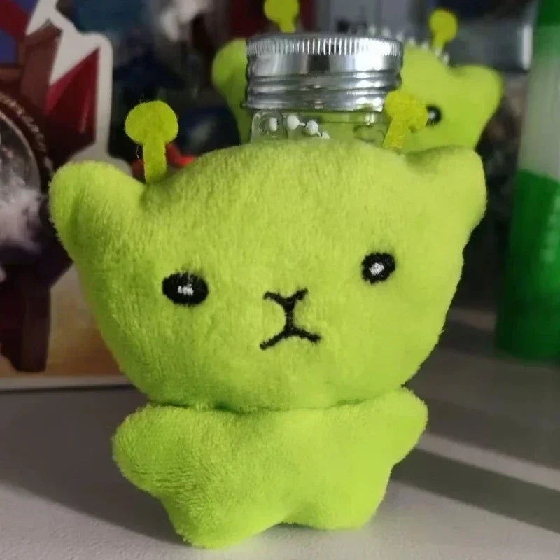 A bright lime green plush alien with yellow antennae is shown against a blurred background.