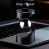 A gray-silver magnetic levitating spinning top resting on a laptop keyboard.