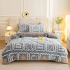 A blue and white patterned plush throw blanket is displayed on a bed, featuring dinosaur designs.