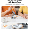 An orange-colored hand holds an orange phone resting on a smooth, silver aluminum base for 360 degree rotation.