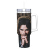A stainless steel tumbler featuring a portrait of a man with dark hair and intense eyes surrounded by sunburst patterns.