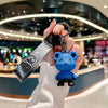 A hand holds a luxury leather key case with a charm shaped like a blue bear for Fiat and Citroen models.