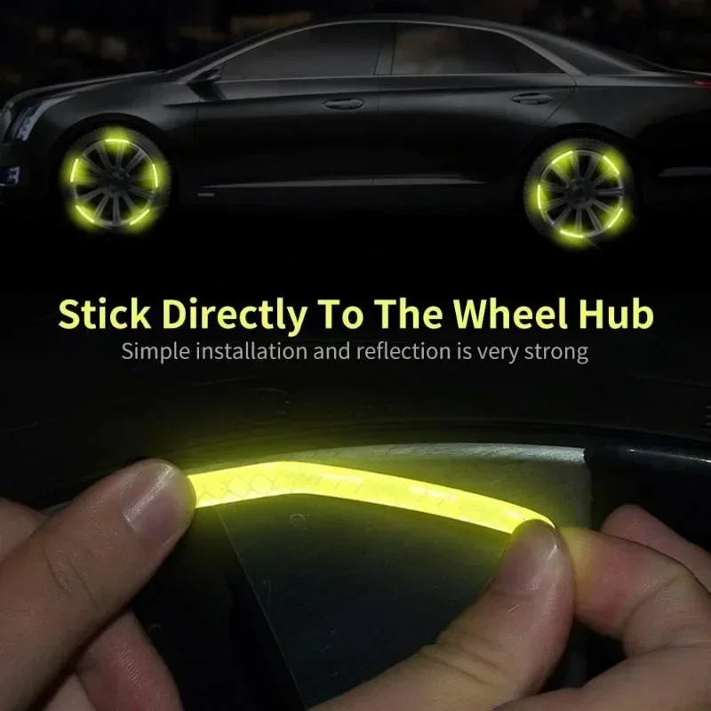 A hand is applying a yellow reflective sticker directly to a car wheel hub for installation.