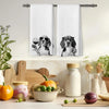 A set of two white kitchen towels featuring illustrations of dogs in glasses and cups.