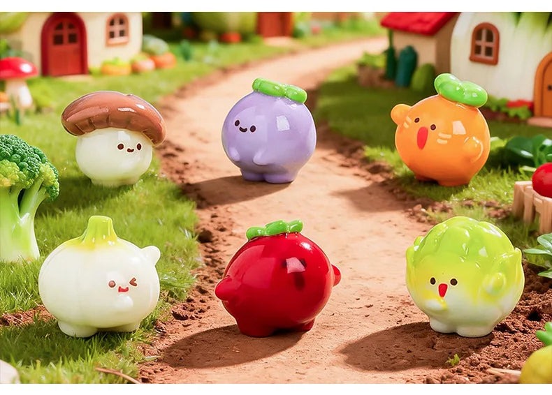 A collection of hand-painted resin vegetable figurines, including a purple eggplant, orange squash, red apple, and green squa