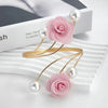 Pink rose pattern curtain tiebacks with gold metal buckles and pearl accents displayed on a white surface.