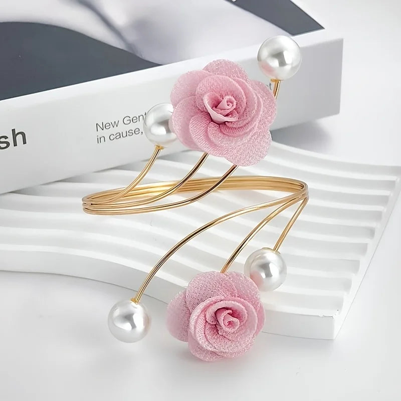 Pink rose pattern curtain tiebacks with gold metal buckles and pearl accents displayed on a white surface.