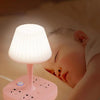 A pink LED night light lamp is placed next to a sleeping baby's head.