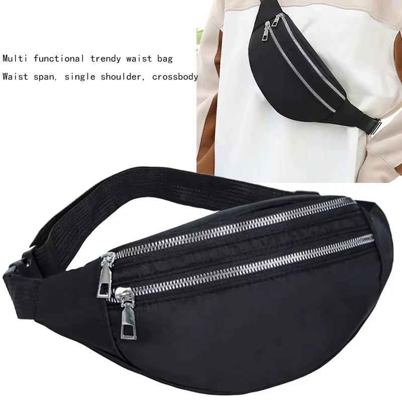Black multi functional trendy waist bag with a zipper and adjustable strap shown against a white garment.
