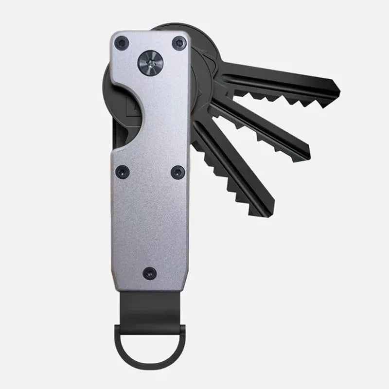 A minimalist aluminum key organizer holding several black keys.