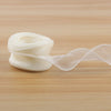 A roll of white satin ribbon, 10 yards long and 40mm wide, lying on a wooden surface.
