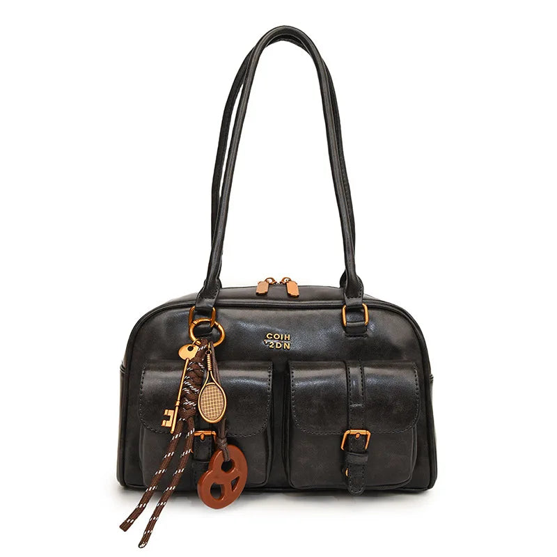 Schwarze Leder-Schultertasche mit goldener Kette und Holzakzenten.