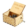 A hand-cranked wooden music box with a lid engraved 'Fly me to the moon' and decorative floral patterns.