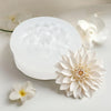 A white lotus flower silicone mold is shown with several fresh white lotus flowers on a light surface.