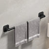 A black wall-mounted towel rack holding a gray towel with white stripes.