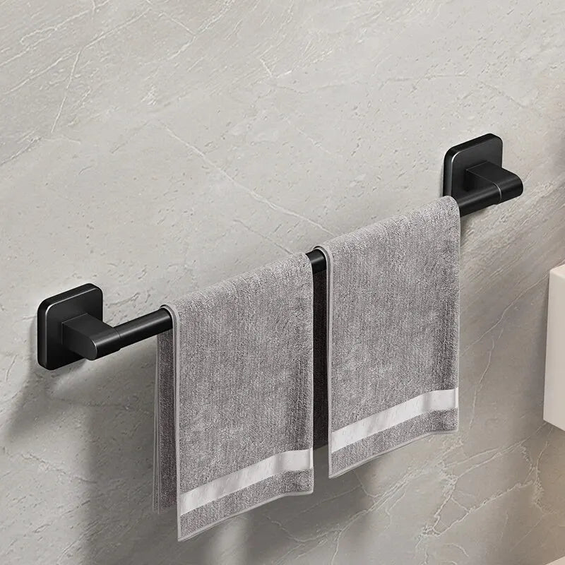 A black wall-mounted towel rack holding a gray towel with white stripes.