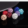 A collection of colorful crystal clay round beads in various shades and sizes displayed on a dark surface.