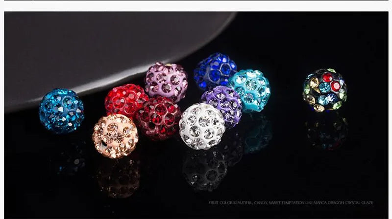 A collection of colorful crystal clay round beads in various shades and sizes displayed on a dark surface.