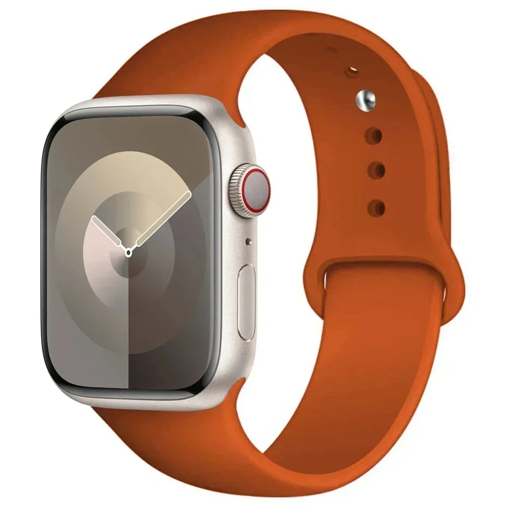 A silver Apple Watch is shown attached to a wide, orange silicone sport band.